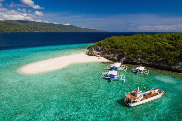 Sumilon Island in Oslob Cebu featuring a white sandbar, crystal-clear turquoise waters, and tropical island scenery surrounded by the marine sanctuary