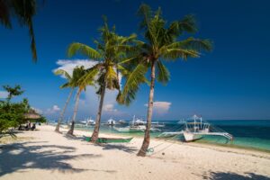 Snorkeling above colorful coral reefs and tropical fish in Malapascua Island, Cebu, Philippines.