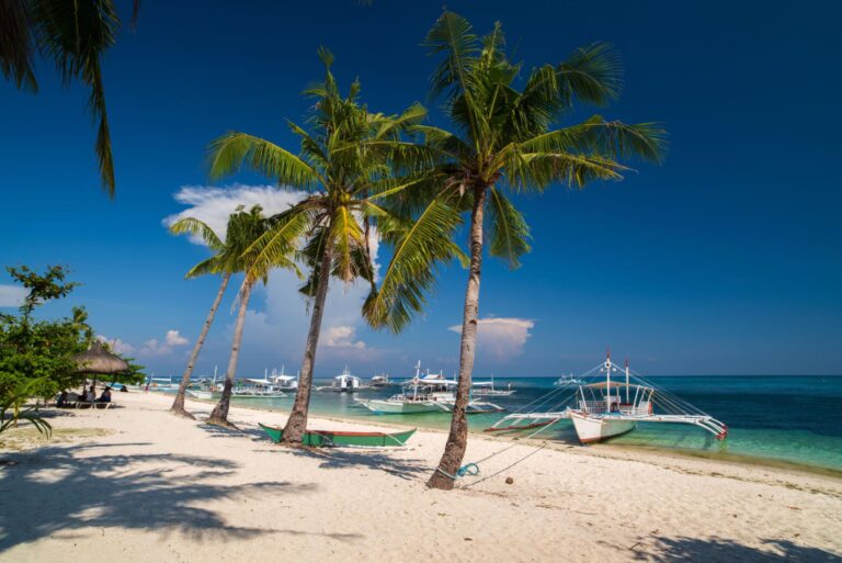Snorkeling above colorful coral reefs and tropical fish in Malapascua Island, Cebu, Philippines.